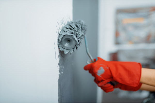 Roller painting a wall